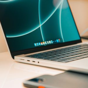 A close-up of a sleek laptop and smartphone on a desk, showcasing modern technology.