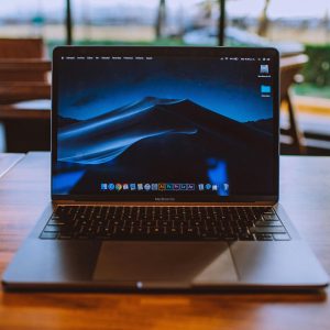 A sleek laptop on a wooden table in a cozy indoor setting, perfect for remote work.